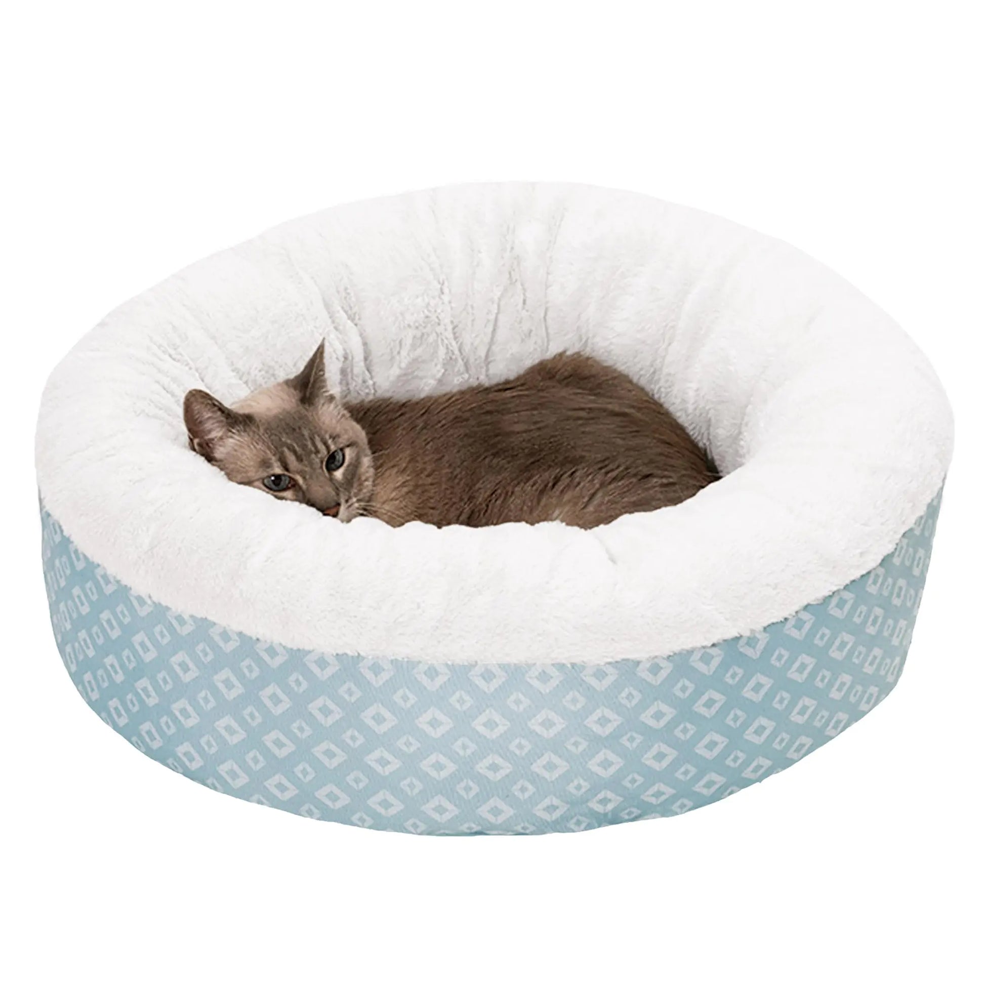Cat lying in a round pet bed with white interior and blue geometric patterned exterior on a white background