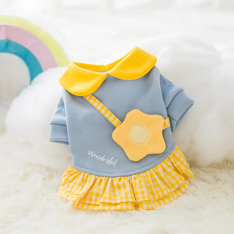 Pet dress with yellow flower and collar on a fluffy white surface