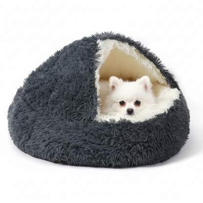Pomeranian relaxing in hooded cave dog bed